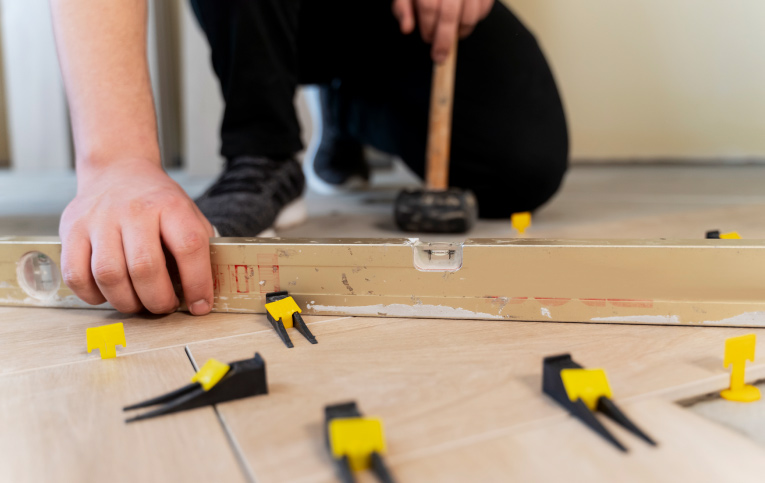 Homem ensinando a como colocar piso no chão