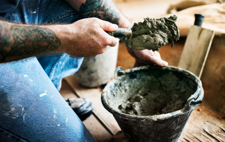 Profissional mostrando como preparar massa de cimento para pequenos reparos 