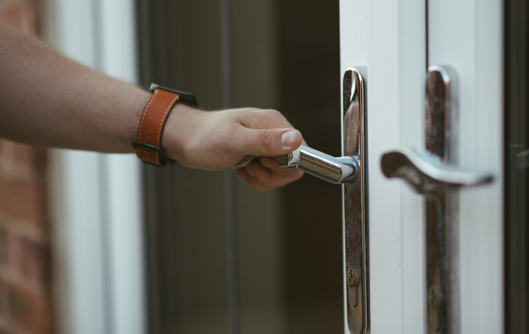 Pessoa pegando em fechadura de porta para trocá-la