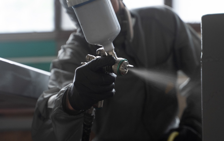 Profissional realizando a aplicação de tinta de alta temperatura