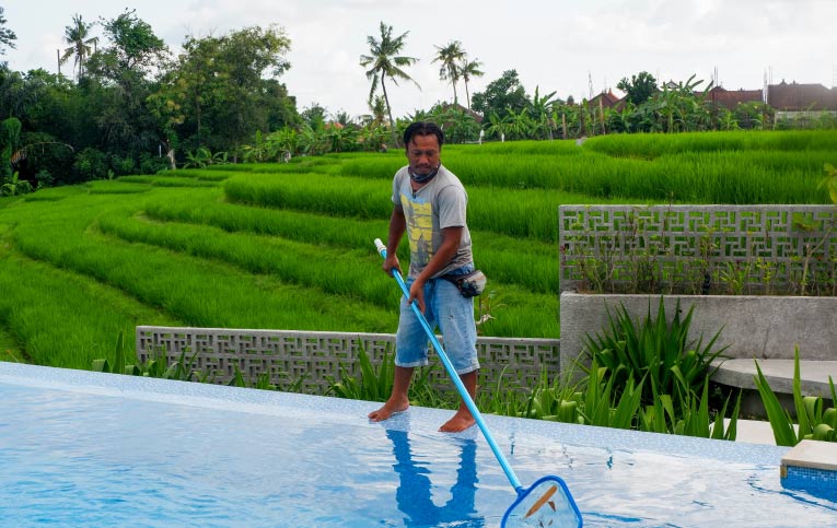 Homem tirando sujeira da piscina